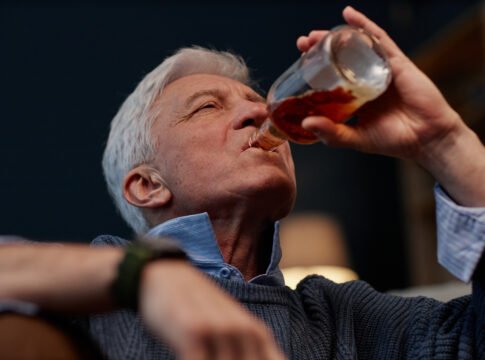 Senior Man Drinking from a Bottle in Cozy Setting Alcohol Destroys Your Gut Bacteria